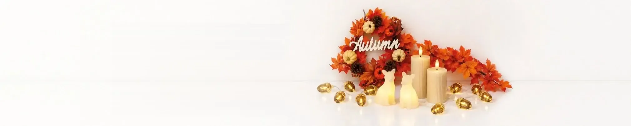Autumn wreath of maple leaves, pumpkins, candles and a string of lights with acorns
